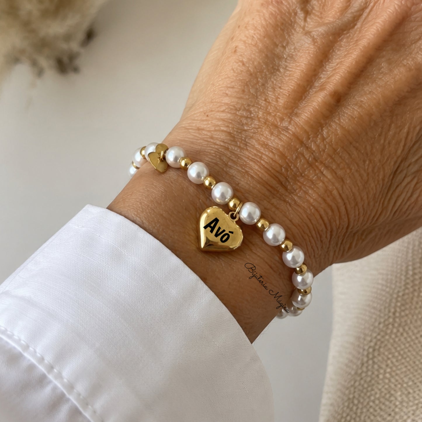 Pulseira Elástica em Pérolas com Coração “Avó” Dourado em Aço